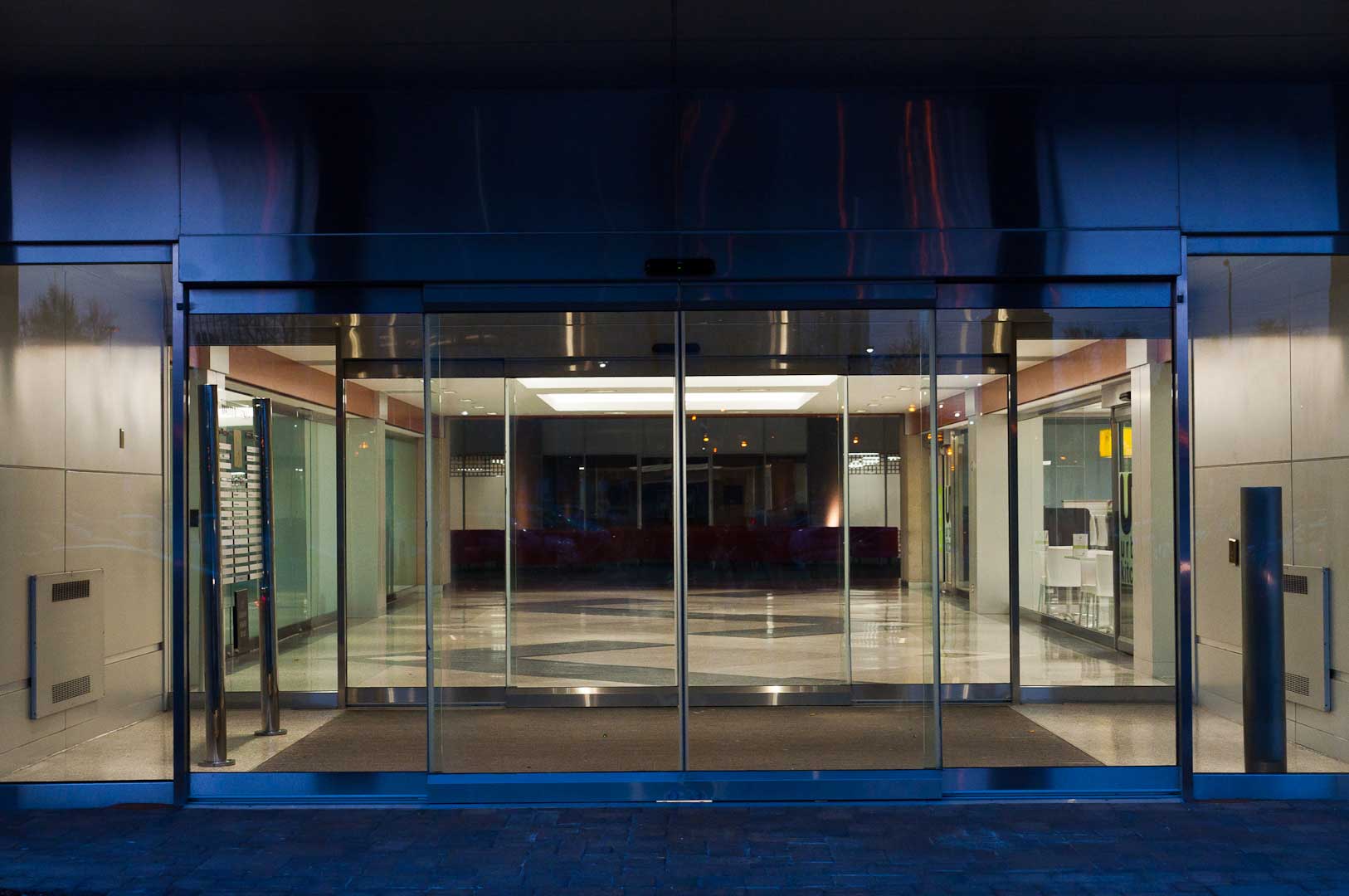 An all glass Tormax Sliding door system showing the exterior of the building